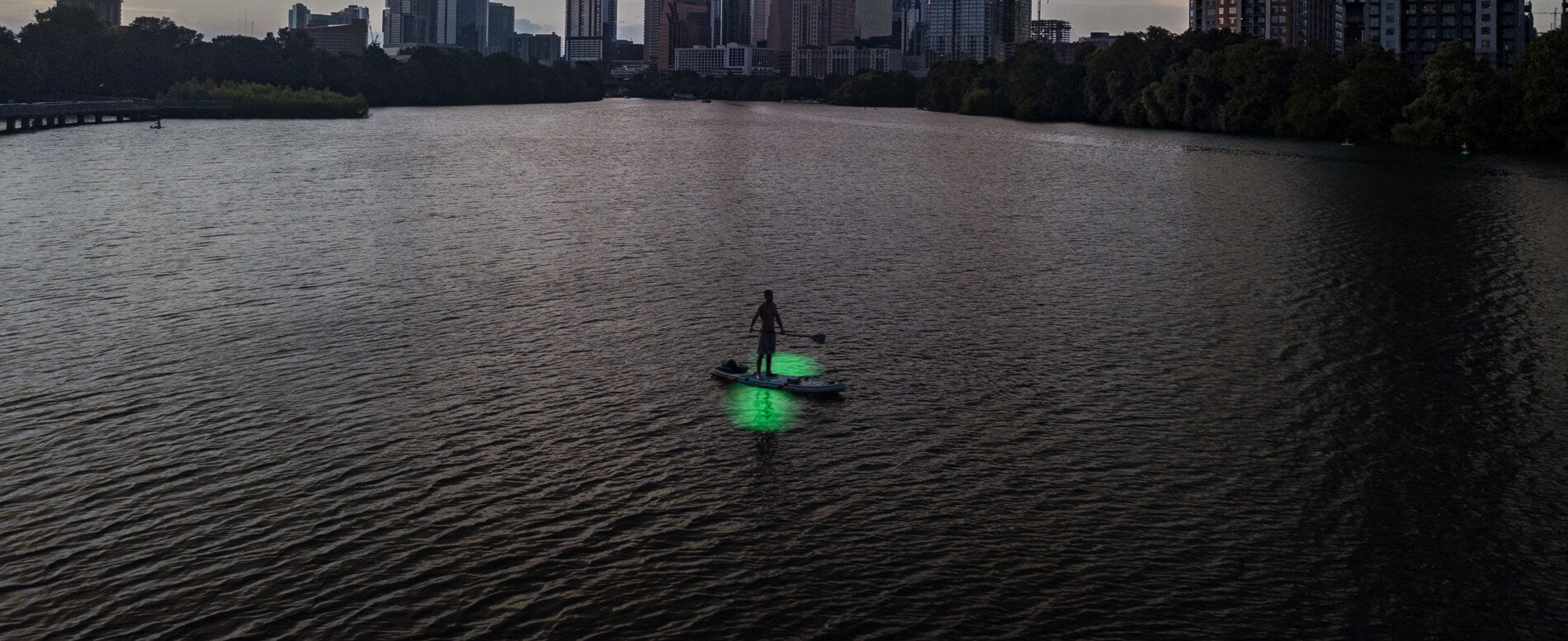 Man paddle boarding at night with LED lights
