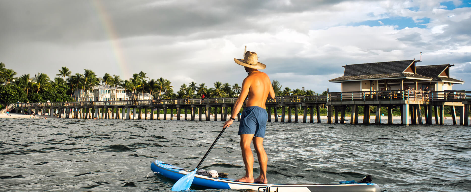 Man paddle boarding with a gili air inflatable paddle board on a beach