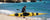 Man carrying yellow sit-in kayak heading to ocean