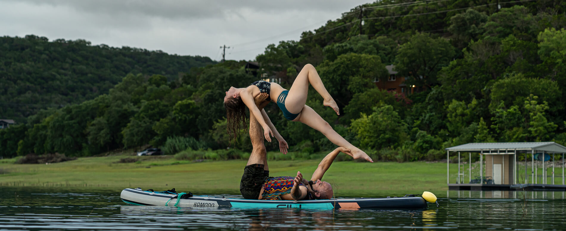 Man and a woman doing yoga pose on a komodo paddle board