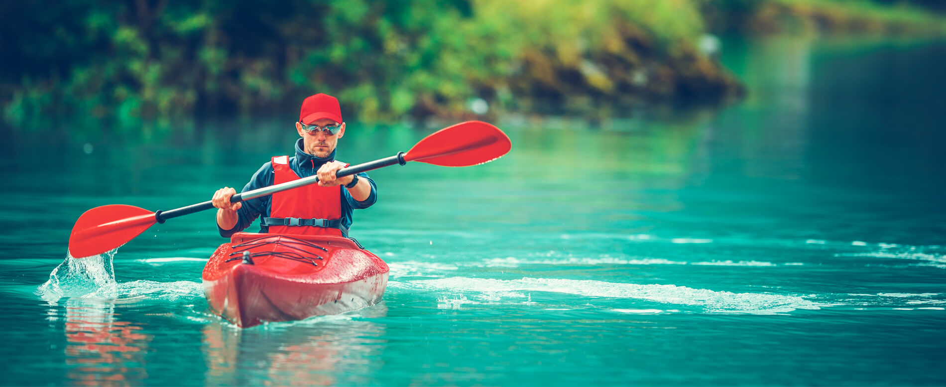 Man kayaking with a red kayak and a red kayak blade
