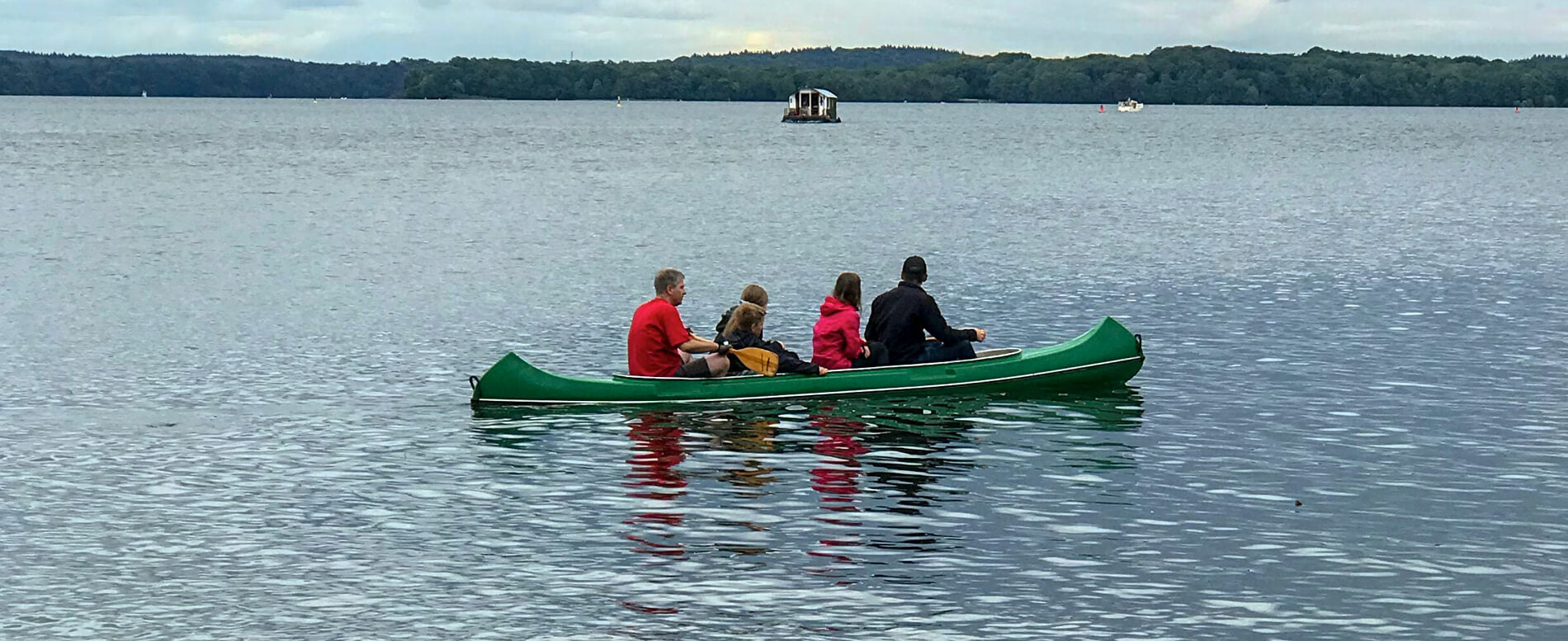 Group of people on a green canoe